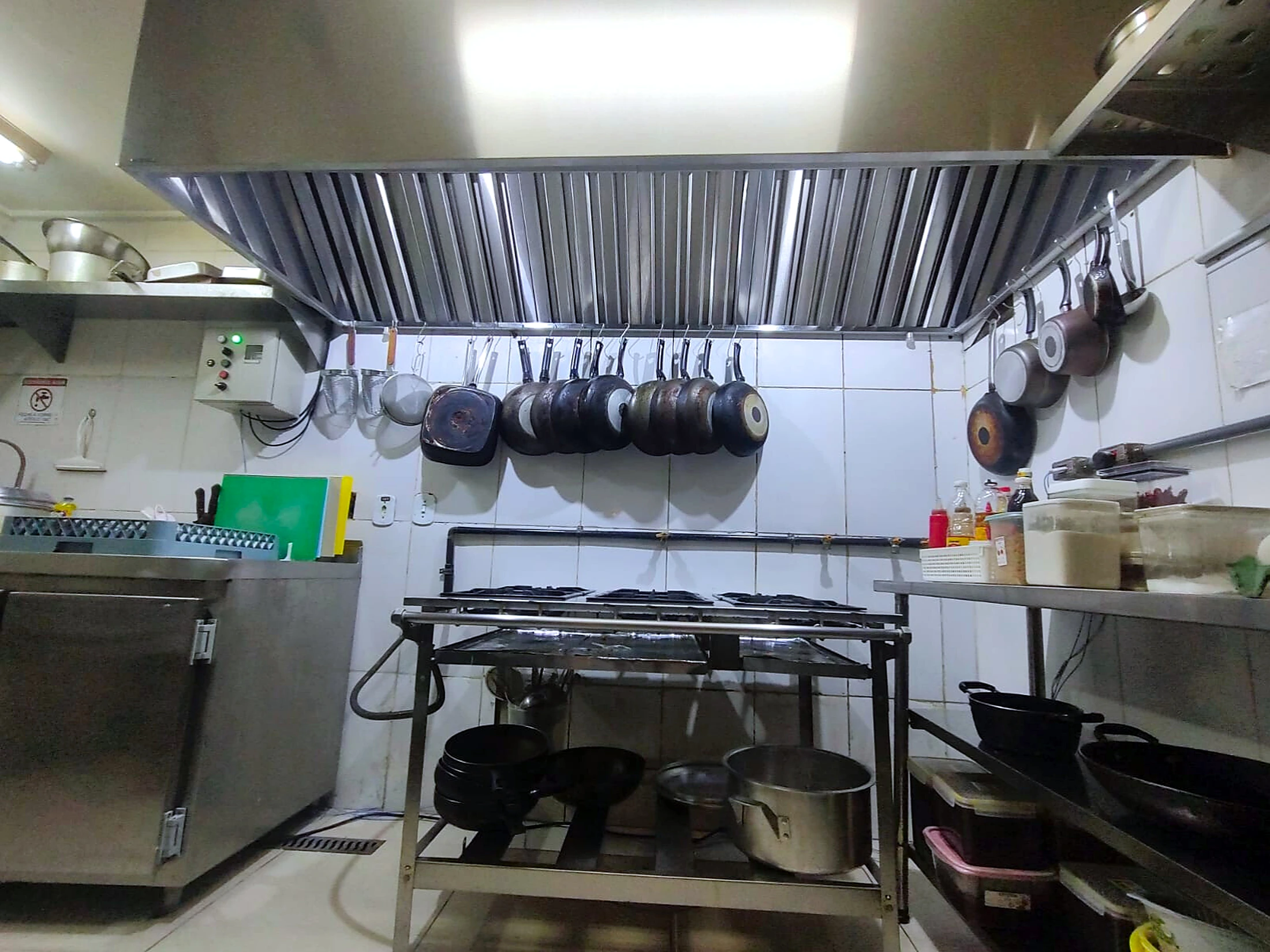 Coifa de parede com filtros sobre linha de cocção profissional